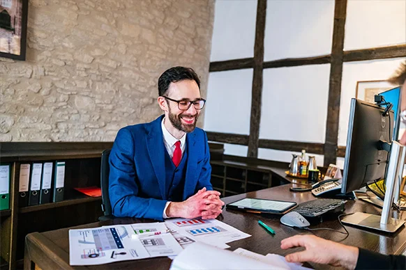 Steuerberater im Gespräch mit Mandant – moderne Steuerunterlagen auf dem Tisch